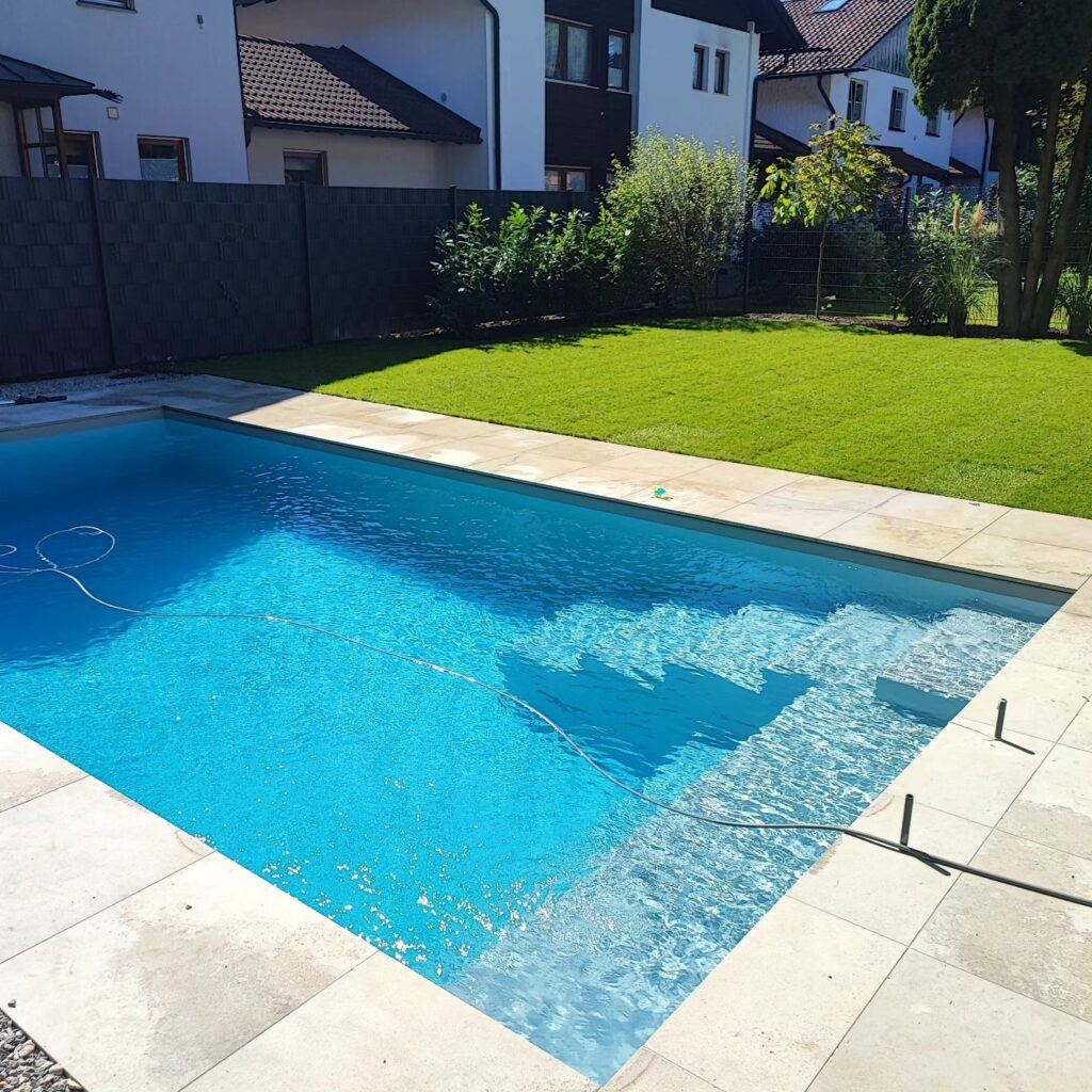 Türkisfarbener Pool mit Treppe und Natursteinumrandung